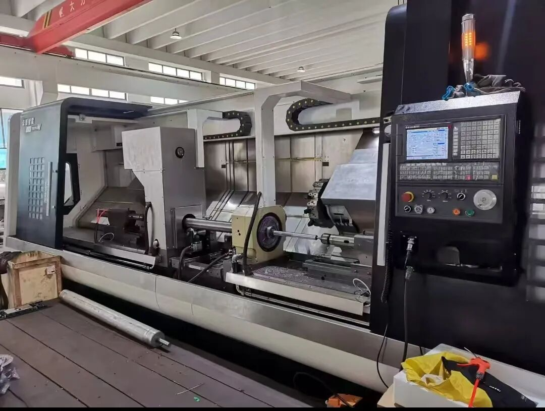 Industrial CNC lathe machine in a factory, featuring a control panel and precision tooling setup.