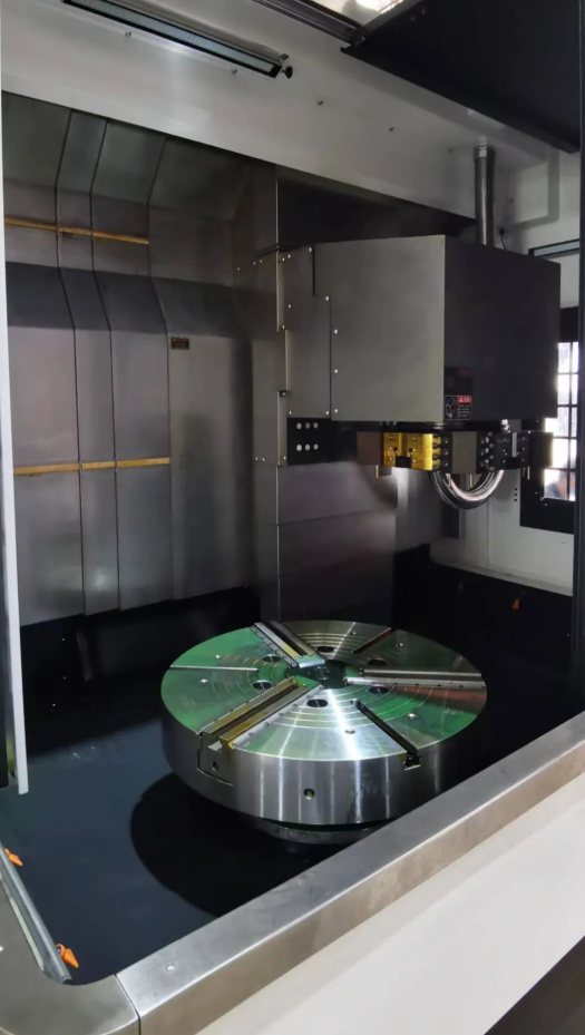 Industrial CNC machine with a large circular metal workpiece.