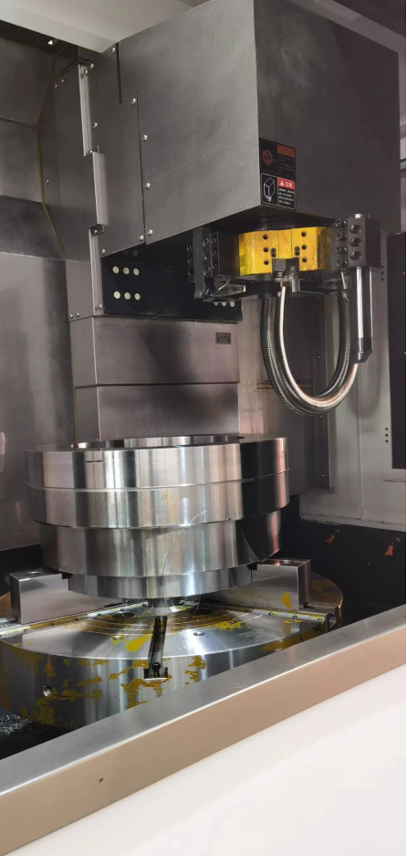 Vertical CNC machine with a metal workpiece.
